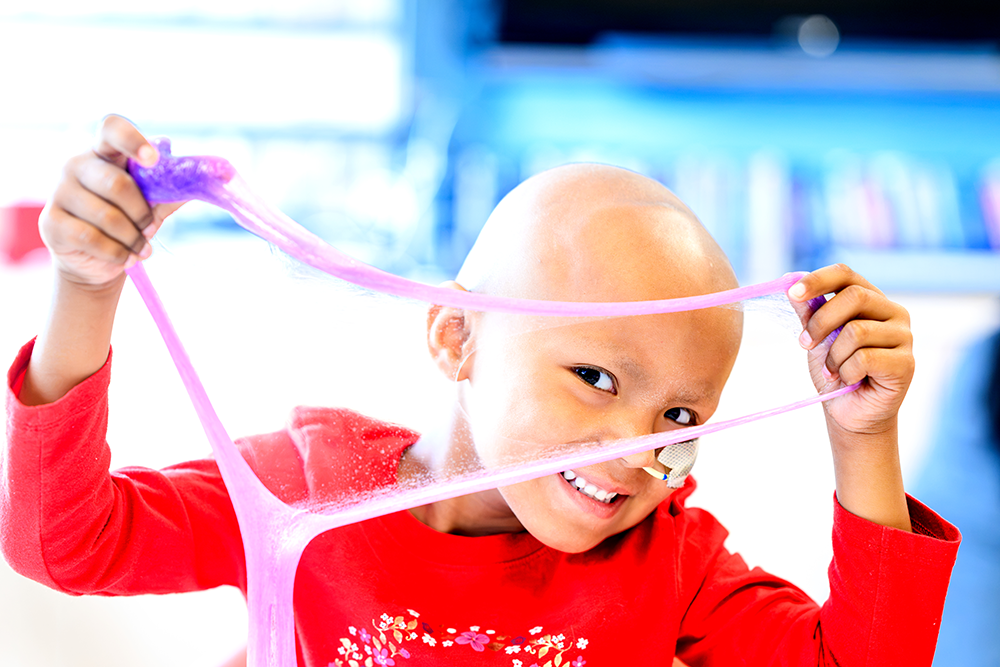child with pink slime smiling