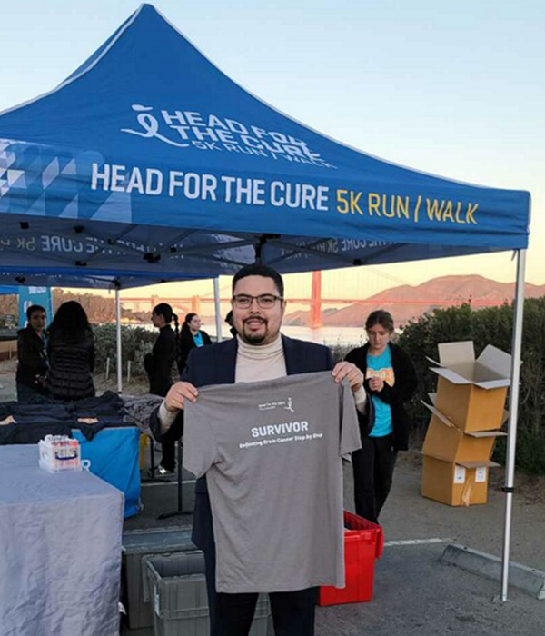 Chris holding up a survivor tee shirt