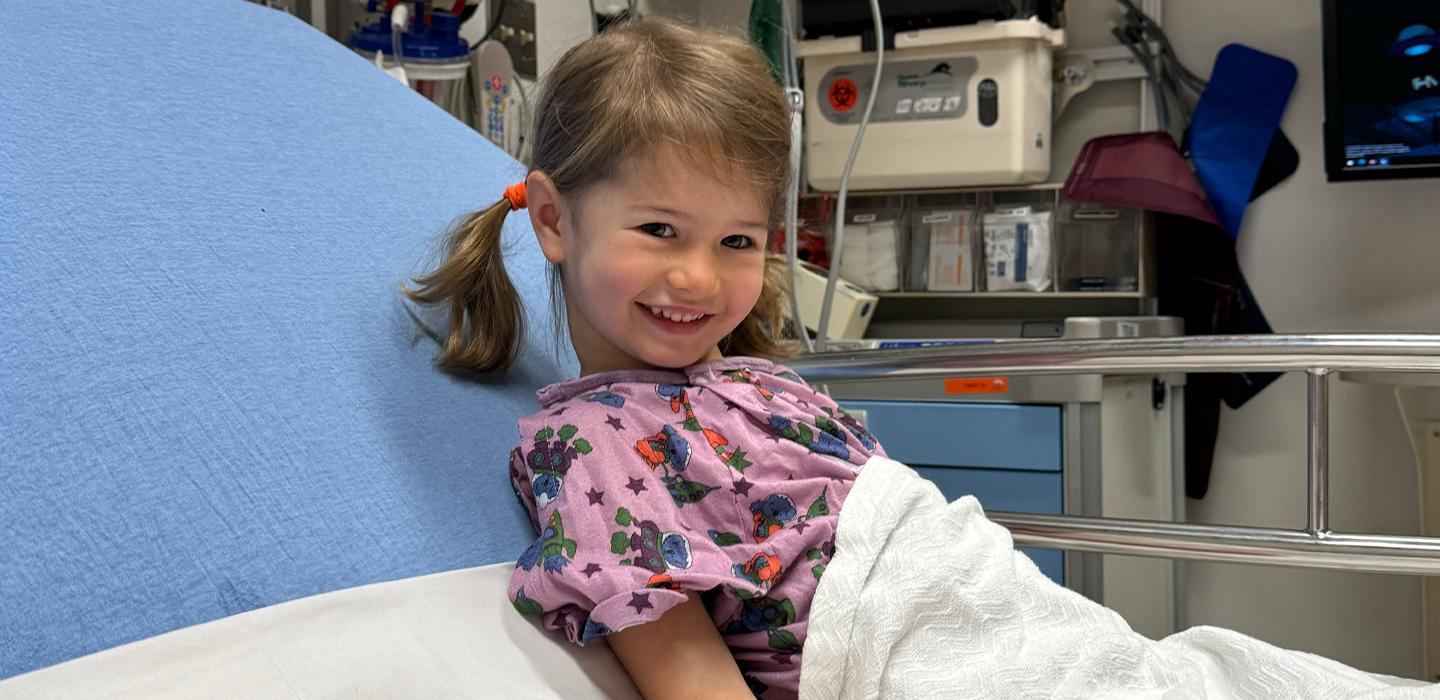Charlie smiles in her patient bed at the hospital