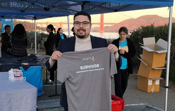 Chris holding up a survivor tee shirt