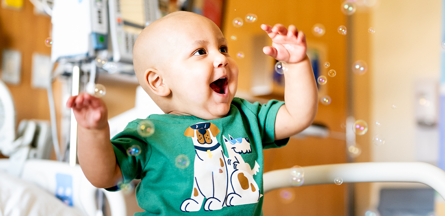 A child smiles at blowing bubbles